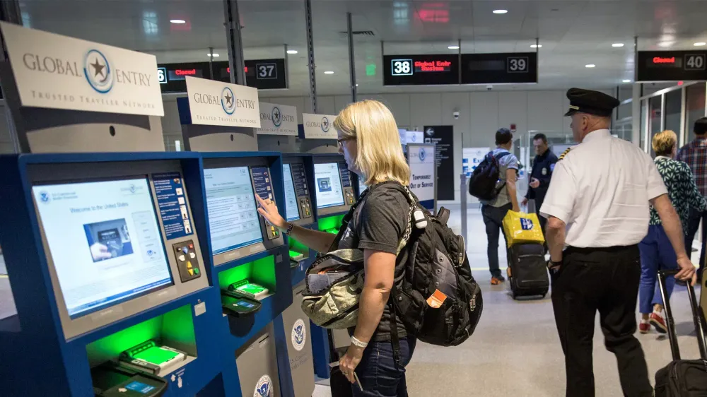 woman at global entry kiosk in Boston airport.
